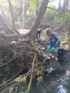 Volunteer cleaning up trash from the banks of the Herring Run stream in Towson.
