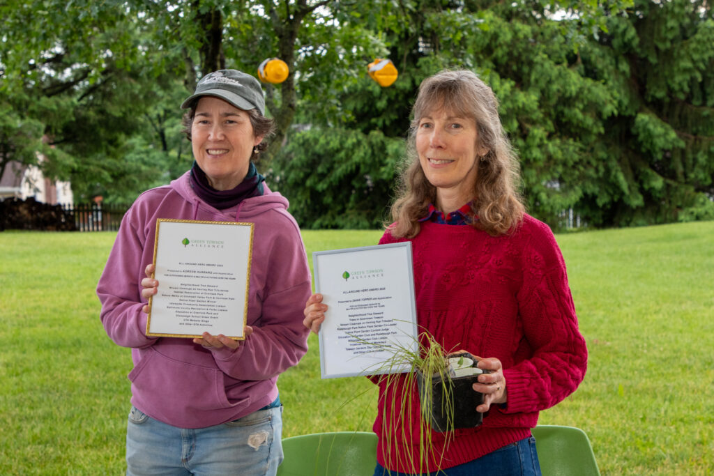 two women holding award certificates